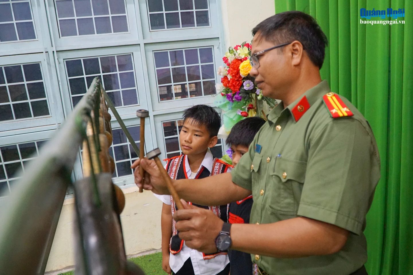 Trung tá A Nhuông tận tình hướng dẫn các em nhỏ đánh cồng chiêng.